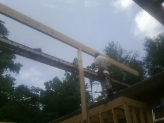 Carpenter setting a ridge beam over a new addition frame — Ice Dam Removal by Roofing Brothers in Johnsonville