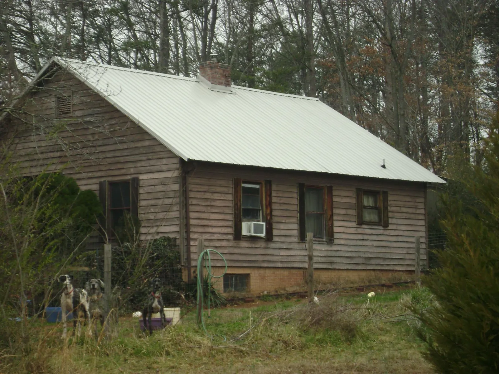 White metal roof on an old wood sided farmhouse, from a Metal Roof Installation job in Johnsonville